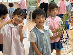 七夕飾りの前でピース